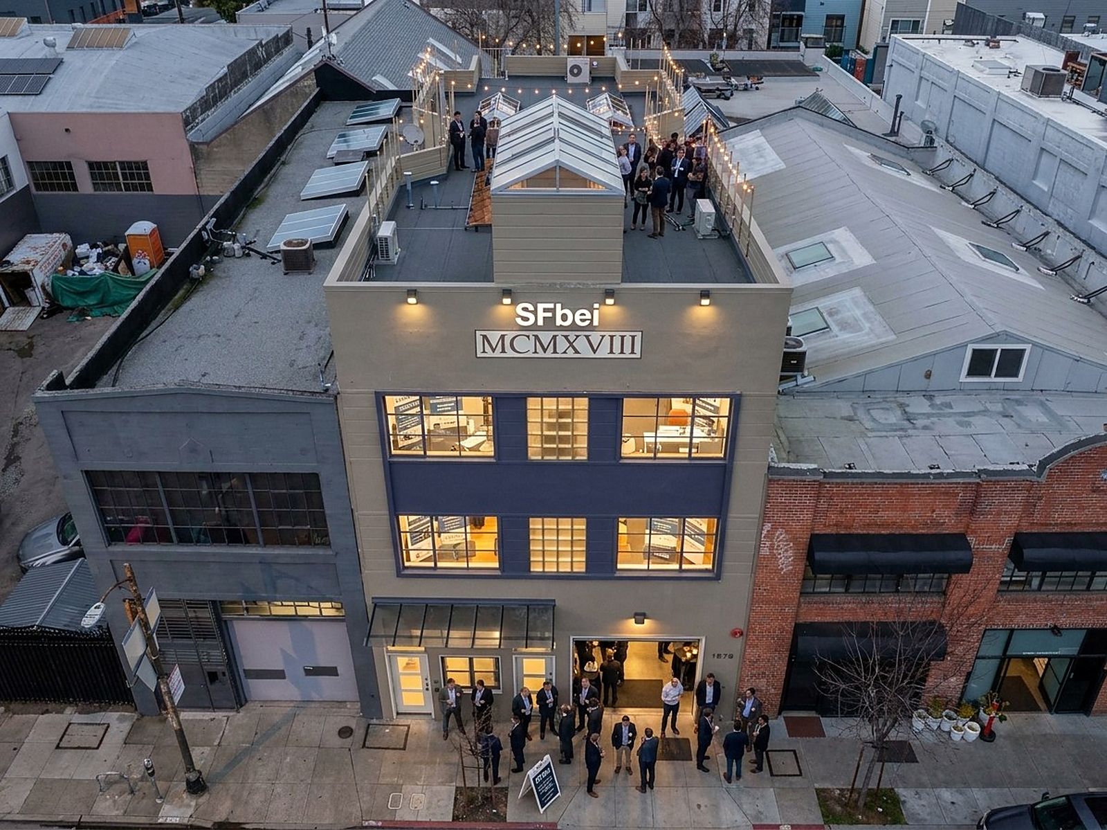 Aerial view of the building lit at night with guests arriving