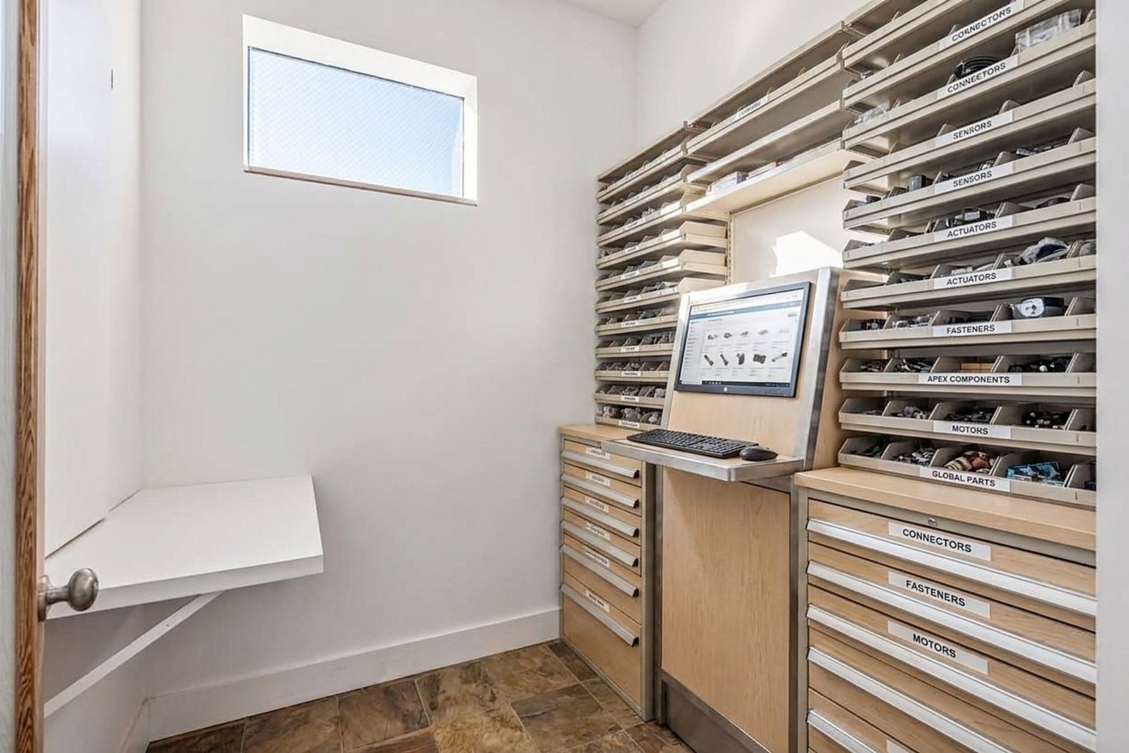 Narrow aisle of labelled component drawers floor to ceiling